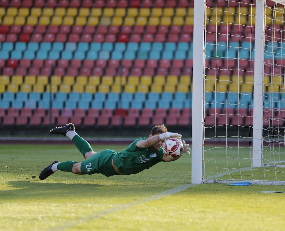goalkeeper diving for the ball to save a goal